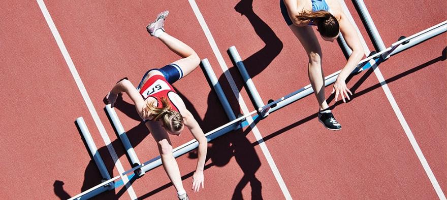 Top down view of racers jumping over a hurdle
